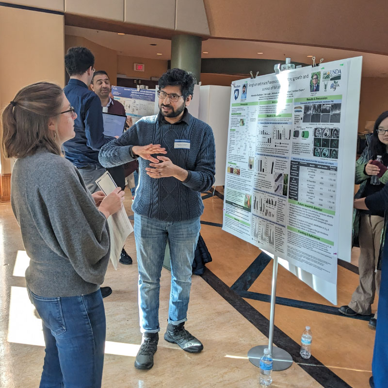 A postdoc discusses his research poster