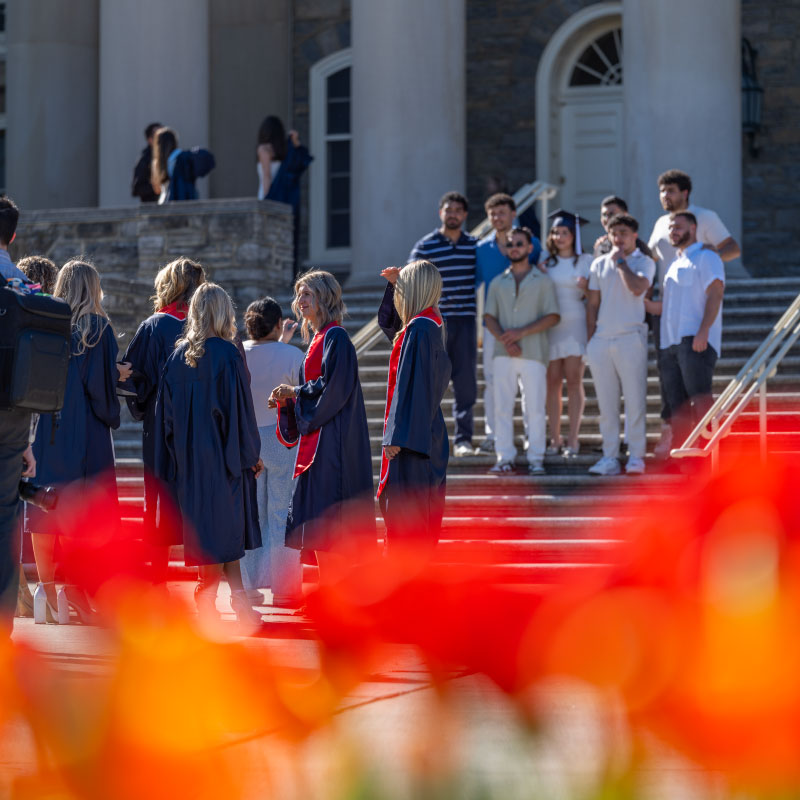 Graduates take photos on the steps of Old Main